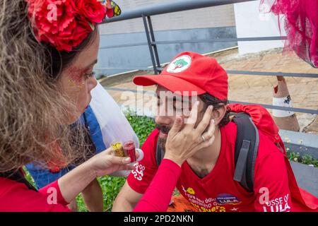 Brasília, DF, Brésil – 01 janvier 2023 : Une femme qui applique des paillettes au visage d'un homme. Photo prise lors de l'inauguration du Président du Brésil Banque D'Images