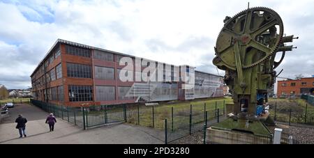 Eisenach, Allemagne. 14th mars 2023. Une presse à dessin profond à double manivelle construite en 1928 se dresse devant le monument industriel 'O1', anciennement l'usine principale de production automobile BMW, sur le site de l'ancienne usine automobile Eisenach. La ville prévoit de construire un hall multifonctionnel dans le bâtiment, qui est vacant depuis plus de 20 ans, pour être utilisé principalement comme un centre sportif pour les sports scolaires, de compétition et de club. Credit: Martin Schutt/dpa/Alay Live News Banque D'Images