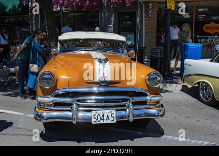 Burlington, ON, Canada - 9 juillet 2022 : 1954 voitures Pontiac garées par des boutiques sur la rue Brant, au salon de l'auto de Burlington. Banque D'Images