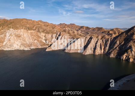 Une vue aérienne d'une rivière qui traverse un paysage accidenté et aride avec un ciel bleu en arrière-plan Banque D'Images