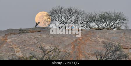 Pleine lune s'élevant au-dessus de la colline rocheuse, parc national Kruger, Afrique du Sud Banque D'Images