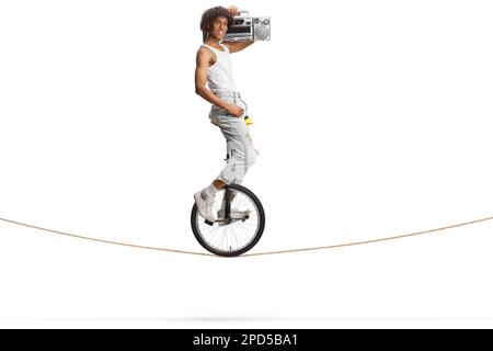 Un homme afro-américain qui monte sur une corde à un monocycle et tient une boombox isolée sur fond blanc Banque D'Images