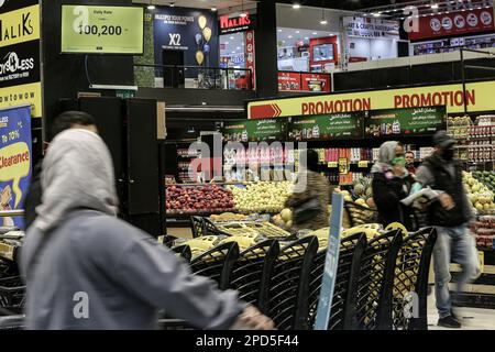 Beyrouth, Liban. 14th mars 2023. Un moniteur (L) affiche le taux de change quotidien du dollar américain par rapport à la livre libanaise à l'entrée d'un supermarché presque vide à Beyrouth après que la livre libanaise ait plongé à un nouveau bas par rapport au dollar américain dans un contexte de crise économique et de blocage politique. Credit: Marwan Naamani/dpa/Alamy Live News Banque D'Images