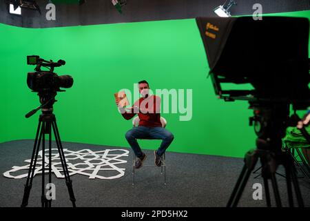 Bosnie-Herzégovine, Sarajevo, 09.november.2022; JOURNALISTE (animateur de télévision) lisant des nouvelles dans une télévision moderne Chroma Key Studio avec télévision, écran vert, Banque D'Images