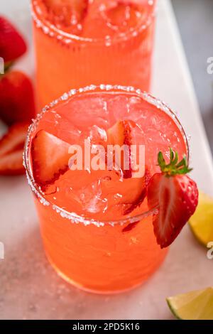 Cocktail de margarita aux fraises avec citron vert et glace pilée servi avec des chips de tortilla Banque D'Images