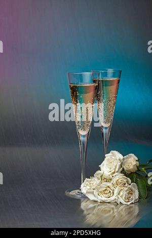 Encore la vie avec deux verres à champagne et un bouquet de roses blanches sur un fond Uni Banque D'Images