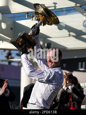 Jockey Nico de Boinville lève le trophée après avoir remporté le Trophée défi de haies Unibet Champion avec Constitution Hill le premier jour du Festival Cheltenham à l'hippodrome de Cheltenham. Date de la photo: Mardi 14 mars 2023. Banque D'Images