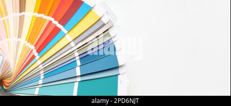 Gros plan du guide couleur. Assortiment de couleurs pour le design. Couleurs éventail de palette sur un fond de mur en béton blanc. Le graphiste choisit les couleurs de la Banque D'Images