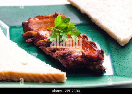 côtes marinées et grillées servies avec du pain grillé Banque D'Images