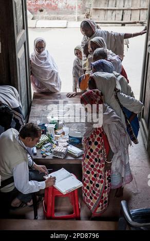 Dr Ghopal; Docteur de l'ONG SOS femme examinant les veuves, Vrindavan, district de Mathura, Inde Banque D'Images