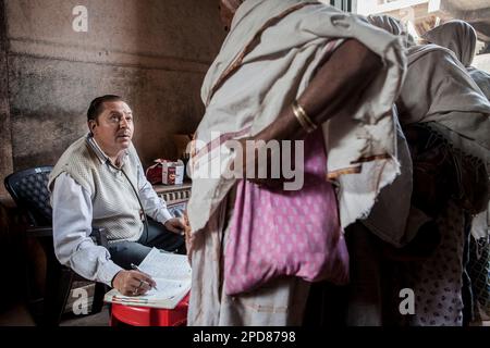 Dr Ghopal; Docteur de l'ONG SOS femme examinant les veuves, Vrindavan, district de Mathura, Inde Banque D'Images