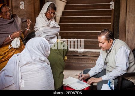 Dr Ghopal; Docteur de l'ONG SOS femme examinant les veuves, Vrindavan, district de Mathura, Inde Banque D'Images