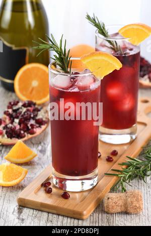 Punch de Noël à l'orange grenade avec glace et romarin. C'est un cocktail sucré, de tarte et rafraîchissant parfait pour célébrer n'importe quelle fête. Banque D'Images