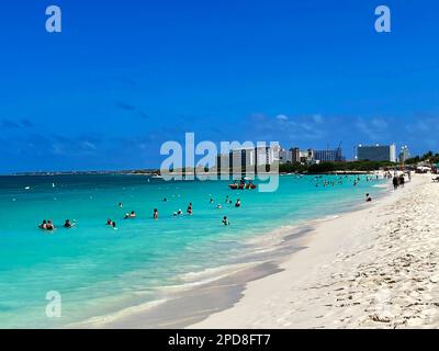 Eagle Beach, Oranjestad, Aruba, 10 mars 2022. Les gens sur la plage et dans l'eau. Hôtels et complexes hôteliers en arrière-plan. Banque D'Images