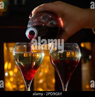 Boisson de Kir Royal, cocktail apéritif français à base de crème de cassis recouverte de champagne, servi dans des verres de tulipe servis au bar Banque D'Images