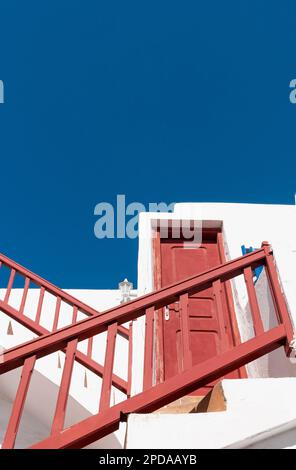 Plan vertical des escaliers extérieurs colorés dans le village de l'île de Mykonos en Grèce contre le ciel bleu Banque D'Images