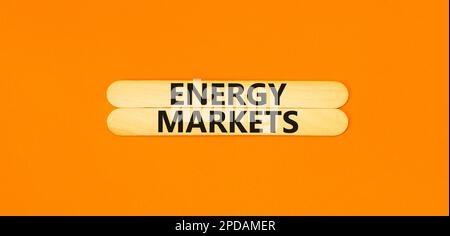 Symbole marchés de l'énergie. Mots-clés marchés de l'énergie sur bâtons de bois. Belle table orange fond orange. Concept des marchés de l'énergie des entreprises. Copier Banque D'Images