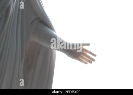 Gros plan de la main crucifiée de Jésus-Christ sur une statue en marbre avec un fond blanc Banque D'Images