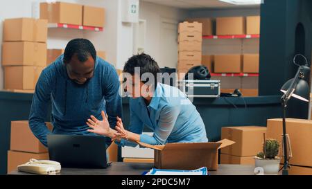 Deux entrepreneurs qui vérifient la chaîne d'approvisionnement sur les étagères des magasins, planifient l'expédition et la gestion du stockage. Jeunes travaillant sur le développement des entreprises et la logistique, la distribution des stocks. Banque D'Images