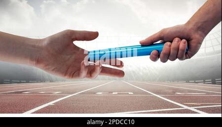 Image de la main de l'athlète passant le relais de bâton sur l'piste de course dans le stade sportif Banque D'Images