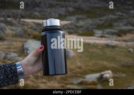 Rester hydraté avec style : femme tenant une bouteille d'eau en acier inoxydable Banque D'Images