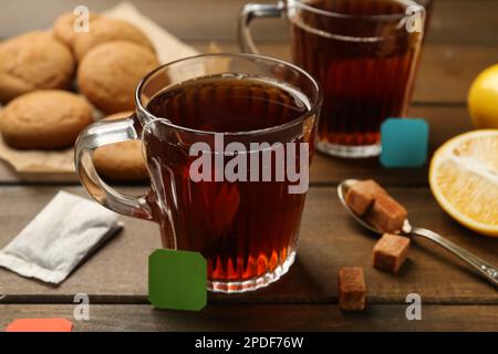 Sachets de thé dans des tasses en verre d'eau chaude et de cubes de sucre Banque D'Images