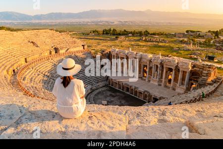 Hiérapolis ville ancienne Pamukkale Turquie, une jeune femme avec un chapeau regardant le coucher du soleil par les ruines de l'UNESCO. Des femmes asiatiques regardent le coucher du soleil à l'ancien amphithéâtre de Turquie Banque D'Images