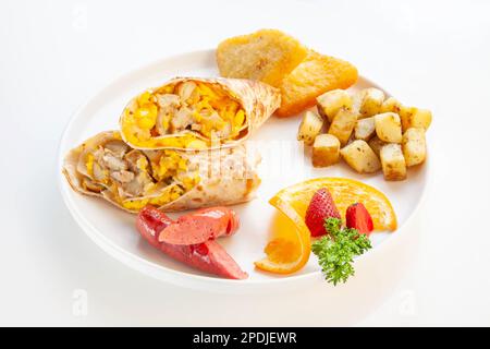 Tortilla envelopper des œufs brouillés avec des pommes de terre sautées et des fruits. Banque D'Images