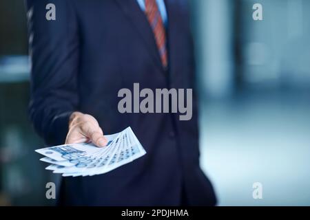 Distribuer un pot-de-vin. Image rognée d'un homme d'affaires avec beaucoup d'argent. Banque D'Images