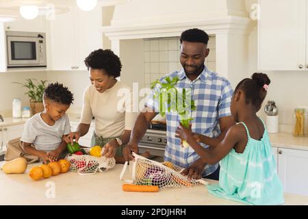 Une famille afro-américaine heureuse qui se décomplaît dans la cuisine Banque D'Images