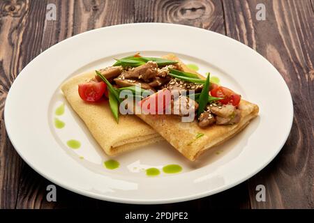 crêpes juteuses avec viande et tomates sur une assiette blanche Banque D'Images
