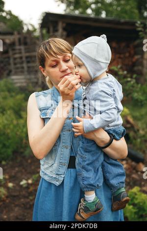 Mère donnant des fraises à son goût. Belle mère nourrissant son bébé garçon. Banque D'Images