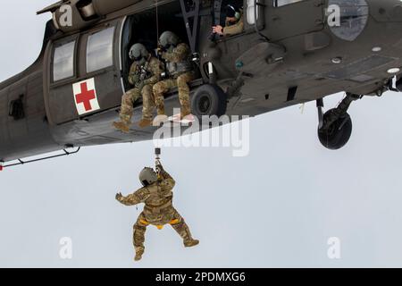 West Greenwich, Rhode Island, États-Unis. 1st mars 2023. Un équipage affecté à C Co, 1st Bataillon 126th Aviation Regiment MEDEVAC, Garde nationale de l'Armée du Rhode Island, dirige UNE formation de qualification DE levage d'hélicoptère UH-60 Black Hawk, sur 1 mars 2023, dans la zone de gestion de Big River, West Greenwich, R.I. Le dispositif de levage est utilisé pour extraire des patients dans des zones trop petites pour qu'un hélicoptère puisse atterrir. La mission de C co est de fournir un soutien d'évacuation aéromédical dans tout environnement opérationnel afin de sauver la vie de nos soldats et de nos partenaires alliés et d'assurer la victoire au combat au sol. (Image de crédit : © États-Unis Banque D'Images