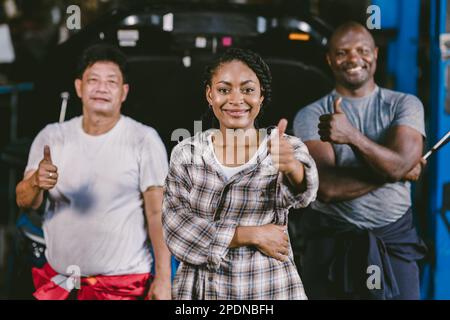 Un groupe de travailleurs de la diversité se fait un grand sourire. Garage mécanicien équipe automobile service professionnels personnes debout ensemble Banque D'Images