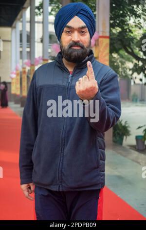 New Delhi, Inde - 04 décembre 2022 - des personnes non identifiées montrant leurs doigts marqués d'encre après avoir fait des votes devant le bureau de vote de l'est de Delhi Banque D'Images