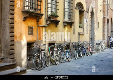 Les vélos garés sur les belles rues médiévales de Lucques, ville connue pour sa ville de l'époque Renaissance intacts les murs, Toscane, Italie. Banque D'Images