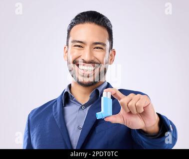 Asthme, pompe et portrait avec un homme en studio sur fond gris tenant un appareil respiratoire pour la respiration. Heureux, sourire et un beau jeune homme Banque D'Images