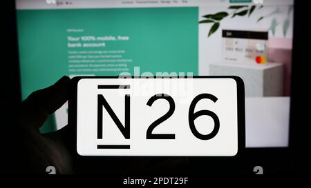 Personne tenant un smartphone avec le logo de la société allemande de services financiers N26 Bank AG sur l'écran devant le site Web. Mise au point sur l'affichage du téléphone. Banque D'Images