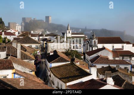 Vue sur Rua Direita dans la vieille ville et les murs d'Obidos dans la brume matinale, Obidos, région centrale, Portugal, Europe Banque D'Images