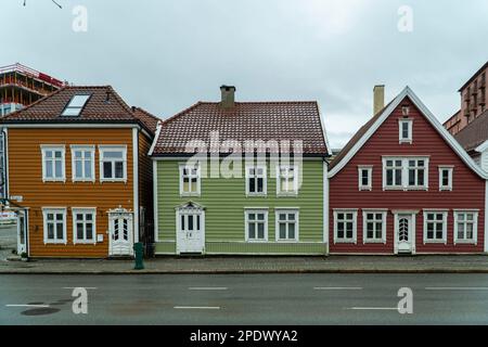 Une scène idyllique avec une rangée de bâtiments en bois colorés avec des cadres de fenêtre blancs situés le long d'une route à Bergen, Norvège Banque D'Images