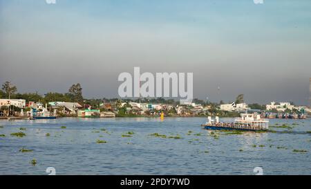 Un ferry traverse le Mékong à long Xuyen, dans le delta du Mékong, au Vietnam. L'air est lourd avec le smog toxique de l'industrie voisine. Banque D'Images