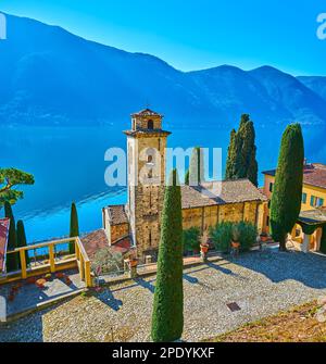 L'église médiévale en pierre de San Sebastiano, entourée de grands cyprès, située sur la rive du lac de Lugano dans le village d'Oria, Valsolda, Lombardie, Banque D'Images