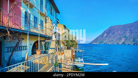 Gandria maison ancienne en pierre sur la rive du lac de Lugano avec bateaux de pêche amarrés et les pentes des Alpes en arrière-plan, Tessin, Suisse Banque D'Images