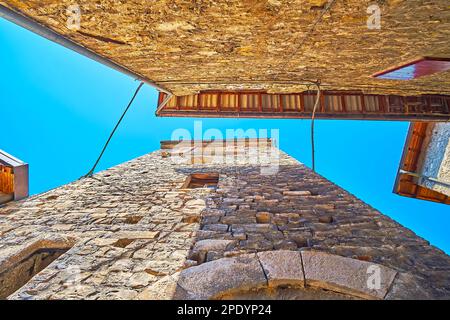 Les maisons hautes en pierre sur la rue étroite avec un ciel bleu vif, vu à travers l'écart entre eux, Albogasio, Valsolda, Italie Banque D'Images