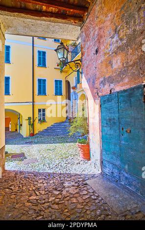 Le col étroit ouvre la vue sur les maisons colorées de Piazza Luigi Danioni à Oria, Valsolda, Italie Banque D'Images