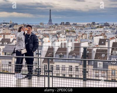 Paris France - 04.06.2022: Sur le toit de Paris un jeune couple prend un selfie avec téléphone mobile avec une belle vue générale de la ville Banque D'Images
