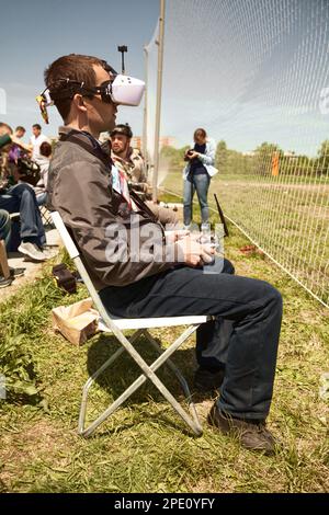 Khabarovsk, Russia - May 21, 2017: Quadcopter pilot wearing video goggles holding a controller.  First person view glasses used to control a vehicle a Stock Photo