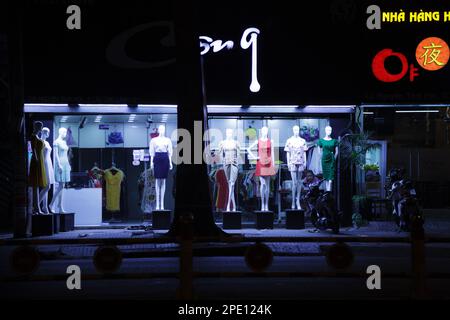 Ho Chi Minh ville, Vietnam - 8 mai 2020 : robes pour femmes exposées sur des mannequins devant un magasin de mode. Jeune asiatique vendeuse seule dans un vêtement b Banque D'Images