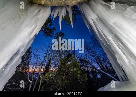 Formation de glace de rideaux illuminée la nuit dans Pictured Rocks National Lakeshore près de Munising, Upper Peninsula, Michigan, États-Unis Banque D'Images