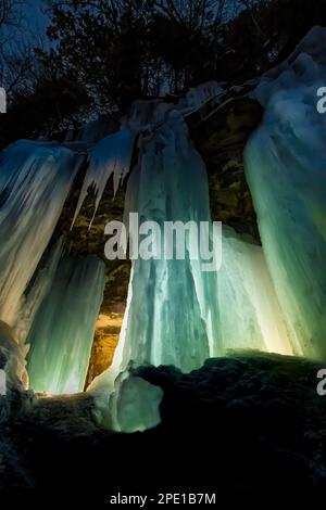 Formation de glace de rideaux illuminée la nuit dans Pictured Rocks National Lakeshore près de Munising, Upper Peninsula, Michigan, États-Unis Banque D'Images